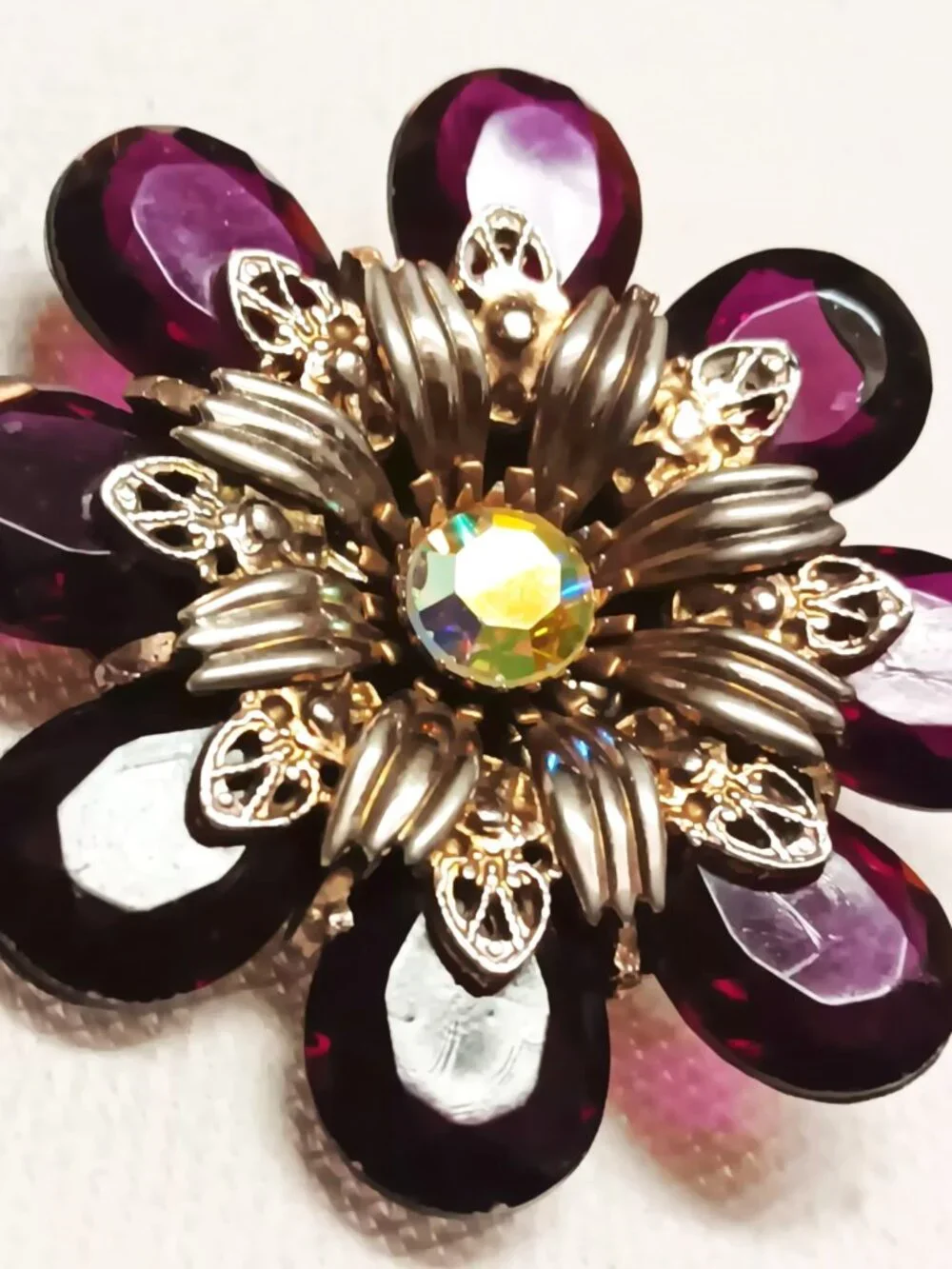 Vintage ruby lucite brooch with aurora borealis central rhinestone.